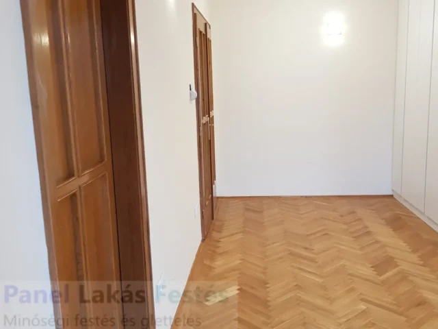 Szobafestés és glettelés fehér falakkal Felújított szoba simára glettelt és fehérre festett falakkal, egyenletes igényes falfelülettel